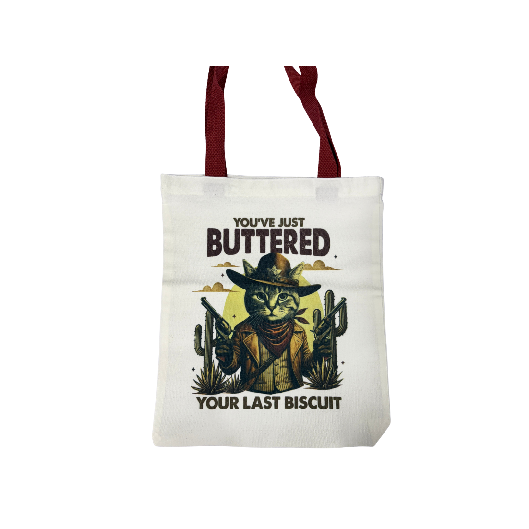 “You’ve Just Buttered Your Last Biscuit” Cowboy Cat | Canvas 14x13 Tote Bag